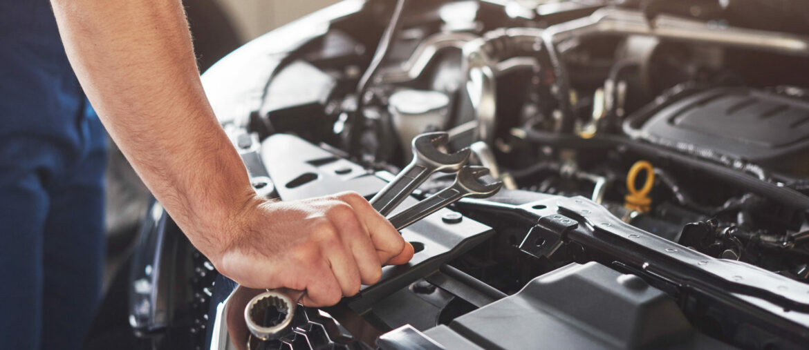 Picture showing muscular car service worker repairing vehicle.